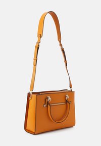 Pomarańczowa skórzana torebka o usztywnionym kształcie, z dwoma górnymi uchwytami i regulowanym paskiem na ramię. Posiada srebrne elementy metalowe oraz kieszeń na zamek.