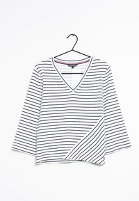 Top bianco a V con righe orizzontali blu navy, maniche a tre quarti e orlo asimmetrico con un piccolo logo del marchio.