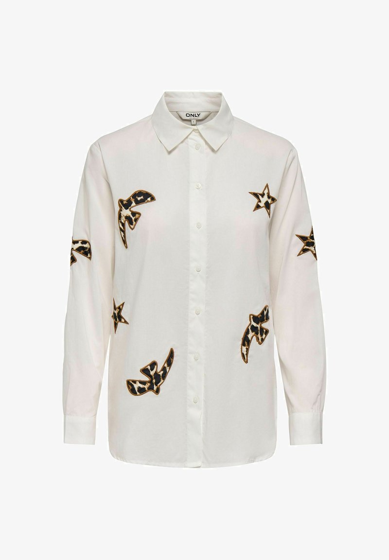 Chemise blanche à manches longues avec boutons, ornée de patches étoiles et oiseaux à imprimé léopard sur le devant et les manches.