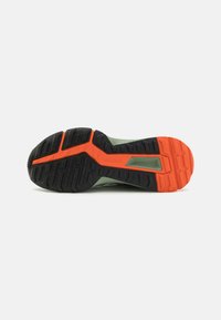 Black and orange sole with a textured tread pattern. Light green upper material, designed for traction and stability in various terrains.