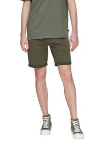 Oliwkowe szorty z podwiniętymi mankietami, wykonane z mocnej bawełny. W zestawie z pasującą oliwkową koszulką i zielonymi trampkami typu high-top.