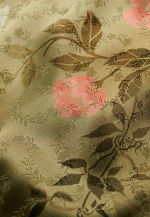 Textielstof met een bloemenpatroon van roze rozen en groene bladeren op een olijfkleurige achtergrond. Glad textuur, zachte glans.