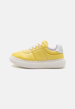 Geel leren sneaker met een witte rubberen zool, ronde neus, gestikte details en witte veters, voorzien van een gevoerde enkel en textuuraccenten.