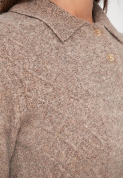 Suave cárdigan de punto beige con patrón de rombos, un cuello puntiagudo y botones marrón claro en el frente.