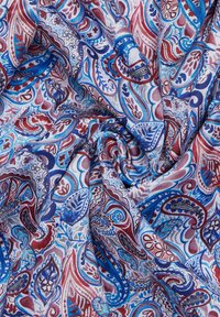 Levendig stof met een draaiend paisleypatroon in blauwe, rode en witte tinten, met een gladde, lichte textuur en ingewikkelde details.