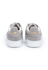Sneakers in suede grigio con suole in gomma bianca. Le caratteristiche includono un design perforato e un retro testurizzato con la scritta "LLOYD" in lettere dorate.