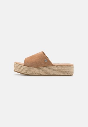 Sandale compensée en daim marron à enfiler avec semelle plateforme en jute tissée, bout ouvert et petit logo métallique sur le côté.