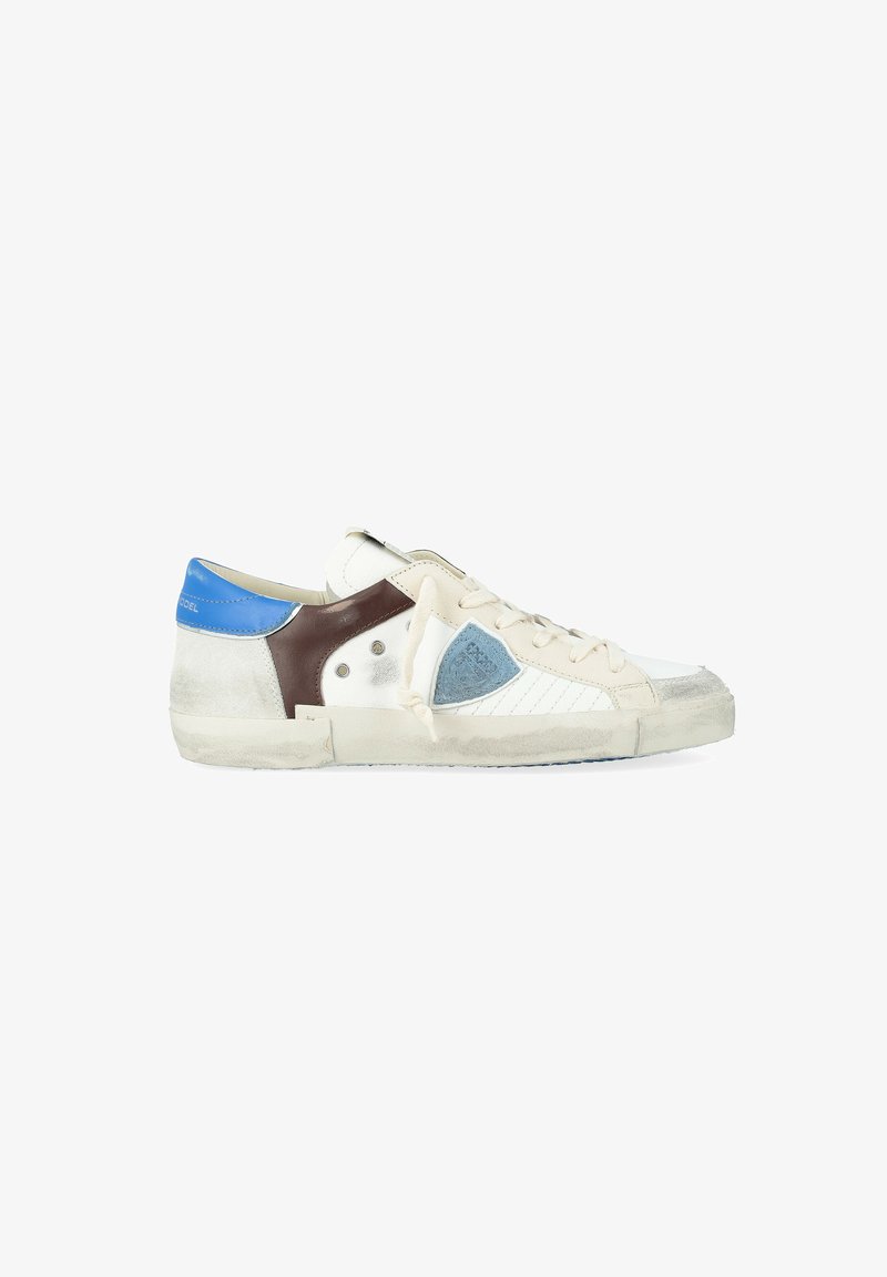 Sneaker bassa bianca con lacci beige, linguetta blu sul tallone, pannelli laterali marroni e blu, e suola usurata e vissuta.
