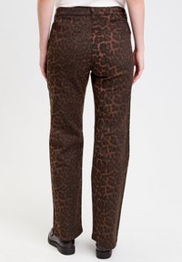 Braun gepunktete Leopardmuster-Hose mit gerader Beinform, ausgestattet mit einer mittelhohen Taille und zwei Gesäßtaschen. Hergestellt aus einem strukturierten Stoff.