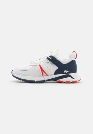 White athletic sneaker with a textured navy overlay, red accents, and a Velcro strap. Features a cushioned sole and mesh panels.