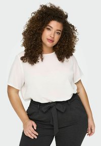 White short-sleeve blouse with a loose fit, paired with high-waisted charcoal trousers featuring a bow tie belt. Smooth texture, no patterns.