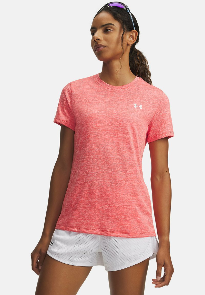 Camiseta deportiva rosa jaspeada con mangas cortas, cuello redondo y un pequeño logo blanco. Combinada con pantalones cortos blancos de malla.
