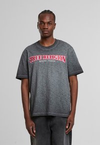 Šedé melírované tričko s krátkými rukávy, které na hrudi zdobí výrazné červenobílé logo "True Religion Brand Jeans".