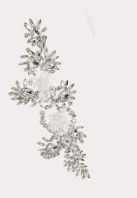 Decorazione in cristallo caratterizzata da un intricato design floreale, con diverse forme e dimensioni di gemme trasparenti e tone argento.