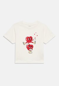 Άσπρο βαμβακερό T-shirt με παιχνιδιάρικο σχέδιο δύο κόκκινων χαρακτήρων καρδιάς με εκφράσεις προσώπου και μικρές κόκκινες καρδιές από πάνω τους.