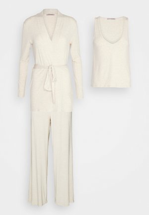 Ensemble de détente beige clair comprenant un haut croisé à manches longues avec lien, un débardeur sans manches assorti et un pantalon à jambe large, le tout en tissu doux et texturé.