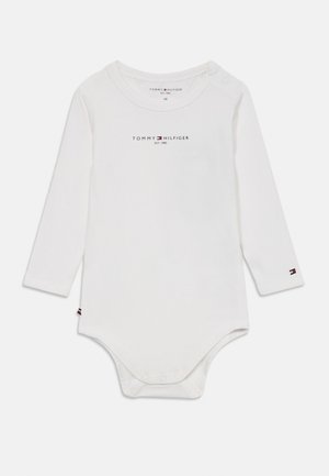 White long-sleeve bodysuit with snap closures, featuring the "Tommy Hilfiger" logo on the front and brand accent at the sleeve. Soft cotton fabric.