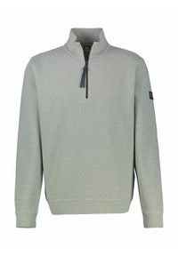 Jasnozielony pulower z ćwierćzamkiem, o prążkowanej fakturze, z długimi rękawami i granatowym suwakiem. Na lewym rękawie znajduje się naszywka z logo.