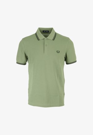 Camiseta polo verde de algodón, con un collar de dos botones, acentos de raya negra en las mangas y un pequeño logo en el pecho.