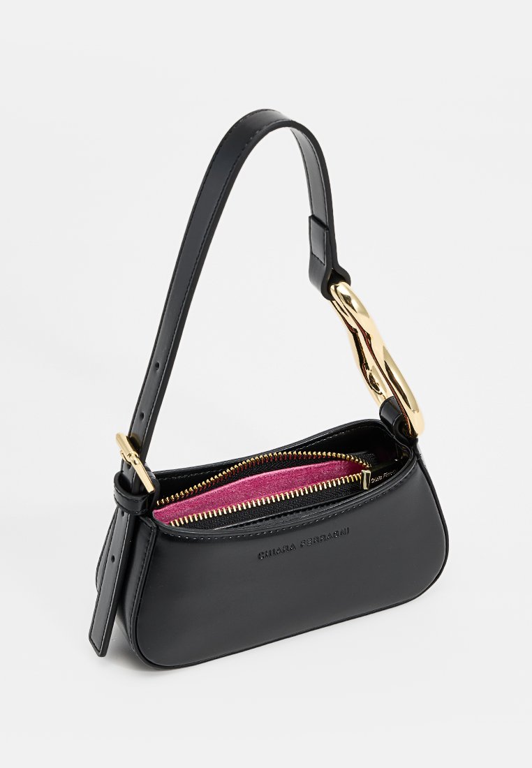 Schwarze Lederhandtasche mit einem einzigen Tragegurt, goldfarbenen Beschlägen und einem pinken Stofffutter. Verfügt über einen Reißverschluss und ein geschwungenes Design.