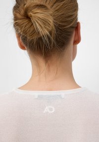 Witte, lichte, mesh trui met een ronde hals en subtiele geborduurde "AD" logo op de achterkant, met een relaxed fit.