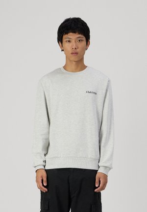 Lichtgrijze sweatshirt met lange mouwen, ronde hals, ribgebreide manchetten en zoom. Bevat zwarte 'Club1990' tekst op de linkerborst.