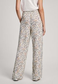 Pantalones de pierna ancha florales en tejido ligero con fondo crema, que presentan un patrón de paisley en azul marino y melocotón, y una cinturilla elástica.