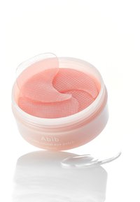Pot rose avec un couvercle contenant des patchs pour la rétine des yeux PDRN. Les patchs sont texturés et semi-transparents, placés dans une substance ressemblant à un gel.