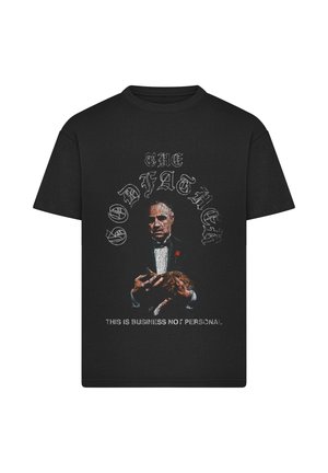 Črna majica s grafiko moškega v smokingu, ki drži mačko, nad njo piše "THE GODFATHER," spodaj pa "THIS IS BUSINESS NOT PERSONAL."