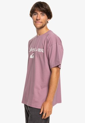 Lavender katoenen t-shirt met korte mouwen, ronde hals en een witte logo-print op de borst. Losse pasvorm en zachte textuur.