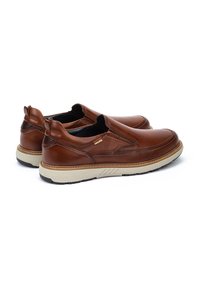 Zapatos de piel marrón tipo slip-on con un acabado texturizado, suela de goma y acentos en beige contrastantes. Presentan paneles elásticos en los lados para facilitar su uso.