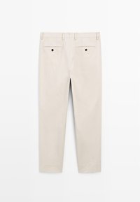 Beige chino's met een recht gesneden ontwerp. Voorzien van twee achterzakken, zwarte knopenaccenten en een gladde, geweven textuur.