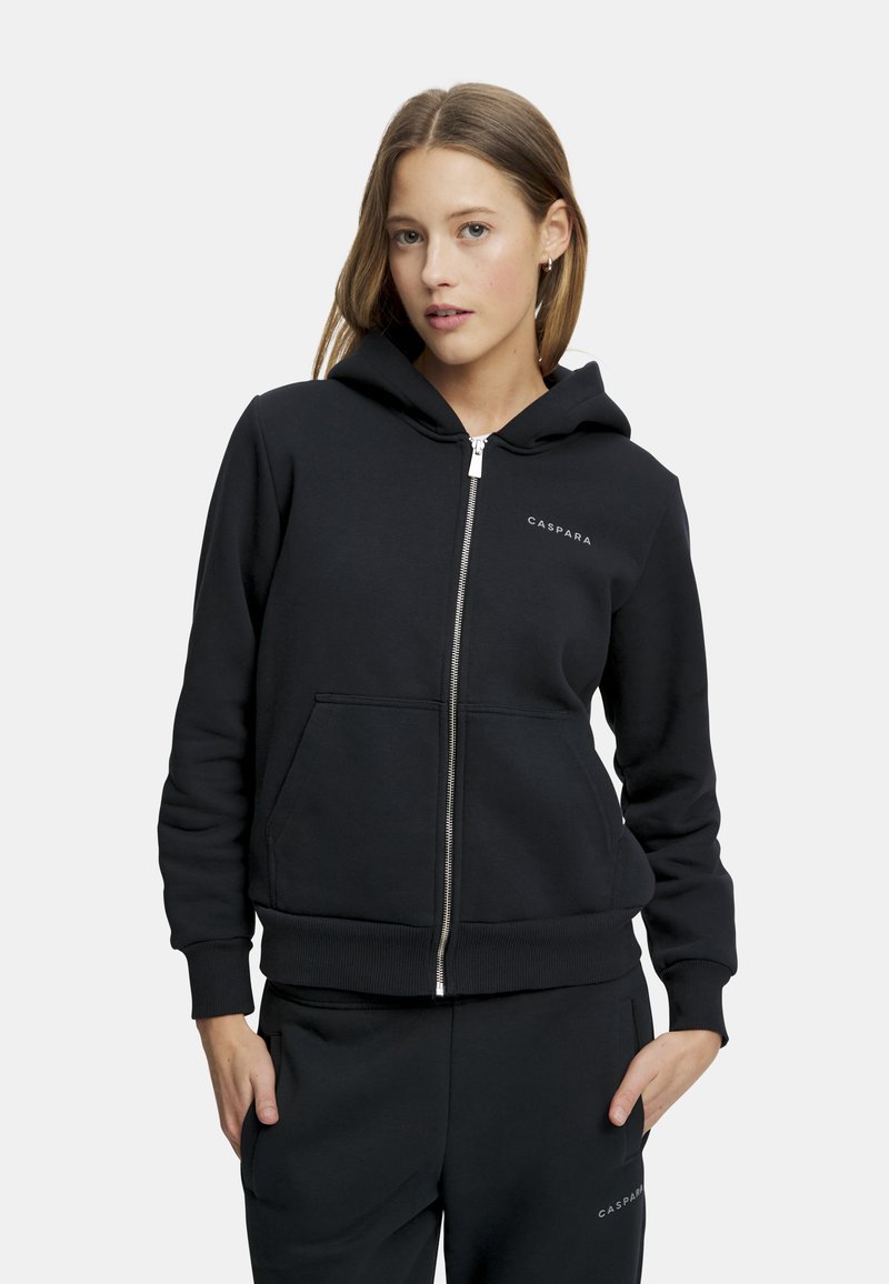 Musta vetoketjuhuppari, joka on valmistettu pehmeästä kankaasta ja jossa on etutasku, ribbaamalla varustetut hihansuut ja vyötärö. Vasemmassa rintamuksessa on logo.