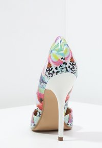 Chaussure à talon colorée avec un bout pointu, arborant un design floral et animal, une finition brillante, et un talon aiguille blanc.