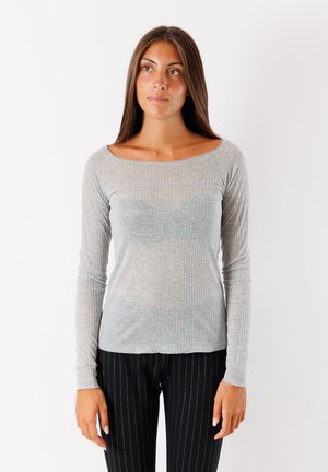 Maglietta a maniche lunghe grigia chiara a costine con scollatura ampia, caratterizzata da un design aderente e una texture morbida, abbinata a pantaloni neri a righe sottili.