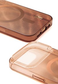 Brunt gjennomsiktig telefondeksel med glitrende tekstur, avrundede kanter, utsparinger for knapper og et minimalistisk design med sirkulære mønstre.