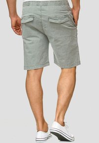Shorts grigi chiaro con vestibilità rilassata, realizzati in tessuto strutturato, con vita elasticizzata e due tasche posteriori con patta.