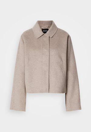 Manteau en laine raccourci de couleur beige clair avec un col, des manches longues et un design de devant épuré. Texture douce sans fermetures visibles.