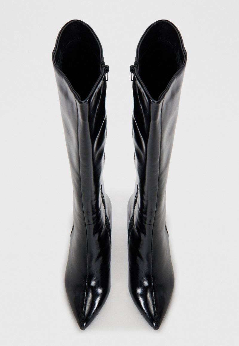 Zwarte leren laarzen tot aan de knie met een spitse neus en een strak ontwerp. Voorzien van een zijrits en een gladde, glanzende textuur.