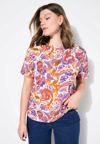 Korte mouwen shirt in het wit met een levendig paisleypatroon in paars, oranje en geel. De stof is soepel; ronde zoom en ronde hals.