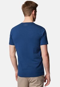 Granatowa bawełniana koszulka z krótkim rękawem, okrągłym dekoltem i kontrastowym logo na plecach. Gładka struktura i dopasowany fason.