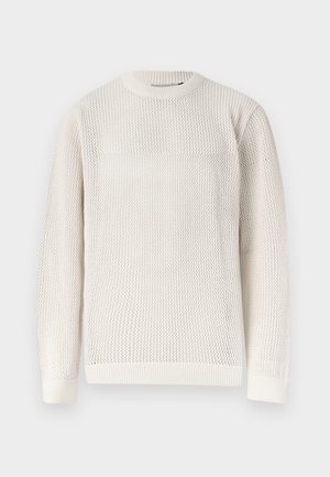 Μπλούζα μακρυμάνικη πλεκτή σε κρεμ απόχρωση με υφή που θυμίζει κυψελωτό σχέδιο και φινιρίσματα με ριμπ γιακά, μανσέτες και τελείωμα.