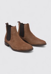 Botas Chelsea de ante marrón con paneles laterales elásticos negros y pestañas para tirar, con puntera redondeada y tacón bajo apilado.