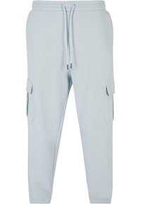 Light blue sweatpants with elastic waistband and drawstring. Features two side cargo pockets and a tapered leg design. Smooth fabric texture.