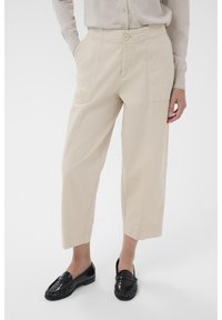 Beiga, korta byxor med sidfickor, knäppning och en avslappnad passform. Matchas med svarta, blankt loafers. Minimalistisk design.