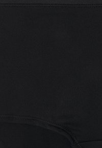 Černé bezešvé kalhotky s vysokým pasem, hladkou texturou, elastickým pasem a jemnými šicími detaily pro pohodlné přilnutí.