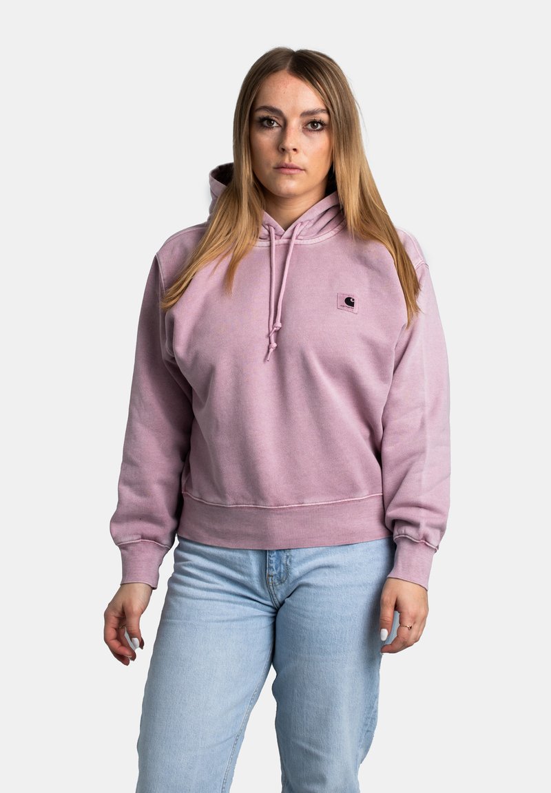 Sweatshirt à capuche rose avec poche kangourou et poignets côtelés, fabriqué en tissu doux. Petit logo brodé à l'avant. Porté avec un jean bleu clair.