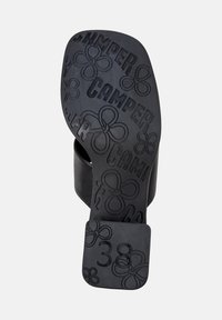 Svart gummisåle med preget "Camper"-merke og blomsterdesign. Har firkantet hæl og størrelsesindikator "38."