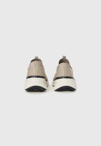 Adidași bej slip-on cu un superior din țesătură texturată, un tab suport la spate și o talpă albă cu pernuțe, având detalii din cauciuc negru.