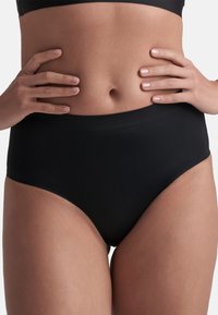 Slip neri a vita alta realizzati in un tessuto morbido e elasticizzato. Presentano un design senza cuciture e una fascia larga per il comfort. Senza chiusure visibili.